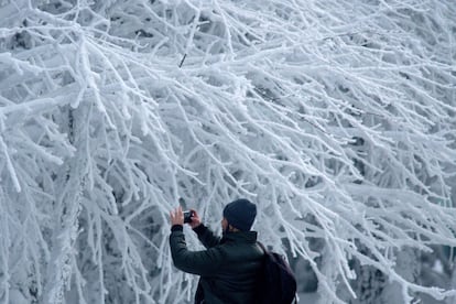 Un hombre saca una fotografía del paisaje nevado en Cabeza de Manzaneda (Ourense), el sábado.