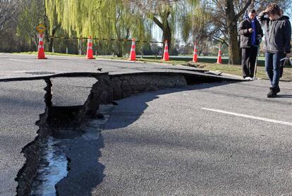 Varios ciudadanos observan los daños provocados por el seísmo en una carretera.