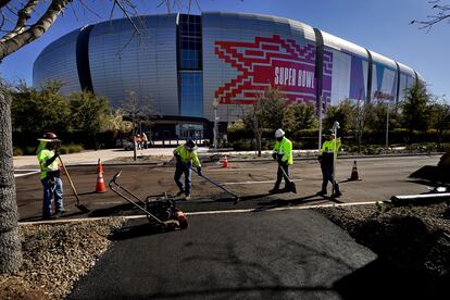 Workers prepare for the NFL Super Bowl LVII football game outside State Farm Stadium, Thursday, Feb. 2, 2023, in Glendale, Ariz.