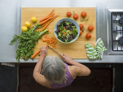 Una mujer prepara una ensalada con verduras, integrantes de la dieta mediterránea.