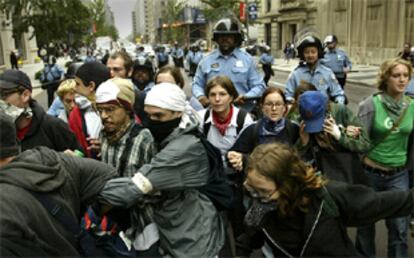 Un grupo de manifestantes de los movimientos contra la globalización corre ante la policía en las calles de Washington.