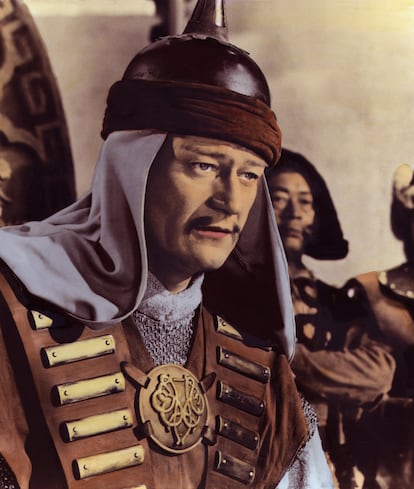 JOHN WAYNE EN 'EL CONQUISTADOR DE MONGOLIA' – Póngase por un momento en la piel de John Wayne. Imagine que está usted a punto de cumplir 50 años y que ya ha hecho casi todo en la vida, de optar a unos cuantos Oscars a protagonizar 'La diligencia' y 'Centauros del desierto', comprarse una fastuosa residencia en las colinas de Hollywood o liderar la principal asociación de actores conservadores de Hollywood. Un productor en el que usted confía, Howard Hughes, un tipo serio, no un tuercebotas sin credenciales, le propone que se ponga en la piel de un personaje histórico, un tal Gengis Kan, guerrero nómada de la estepa euroasiática del que usted nunca ha oído hablar, pero que al parecer fue muy importante en su día, un héroe para su gente, los llamados mongoles, que son como los chinos, pero distintos. Es una película de acción y aventuras de RKO, compartirá usted rodaje con Susan Hayward y Agnes Moorhead y gente divertida como Pedro Armendáriz. Además, no es otro 'western', así que supone la oportunidad de que dejen de encasillarle, y con lo que piensan pagarle va a cubrir usted al menos un par de años de cuotas hipotecarias. Por supuesto, la operación implica algún que otro peaje, como intentar pronunciar sin reírse las frases de un guion indigno de tal nombre, soportar la bisoñez de un director (Dick Powell) que en realidad es un cantante y actor mediocre al que la claqueta se le cae de las manos, embadurnarse las pestañas de kohl para parecer vagamente oriental y lucir uno de los mostachos más ridículo de la historia del atrezo cinematográfico. El resultado acaba siendo una película calamitosa, la peor que recuerda, pero tampoco pasa nada, porque antes de que la estrenen habrá tenido tiempo usted de rodar un par más. 