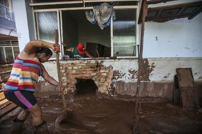 Casal tenta limpar a casa em Barra Longa.
