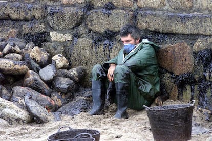 Muxía (A Coruña), 30 de noviembre. Un participante en las tareas de limpieza de la contaminación del petrolero <i>Prestige</i> se toma un descanso en la playa de O Coido.