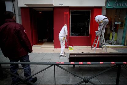 Operarios trabajando en la fachada donde se encontraba Falcón Viajes, la agencia de viajes fictícia creada por las Juventudes del Partido Popular en calle Ferraz, el 15 de abril de 2019.