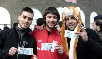 Aficionados del Athletic muestran las entradas recién compradas para ver el derbi vasco.