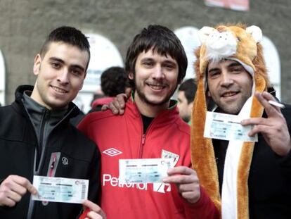 Aficionados del Athletic muestran las entradas recién compradas para ver el derbi vasco.