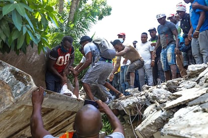 Varias personas realizan tareas de búsqueda de supervivientes tras el terremoto, en Los Cayos (Haití), este sábado.