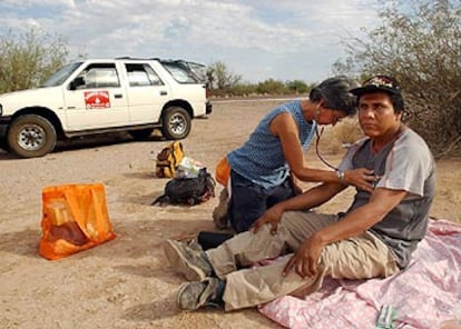 Una voluntaria atiende en Arizona (Estados Unidos) a un emigrante mexicano que sufre deshidratación.