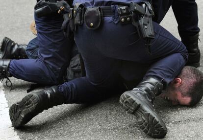 Un policía inmoviliza a uno de los manifestantes.