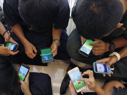Varios jóvenes juegan al videojuego 'Pokemon Go' desde su teléfono móvil.