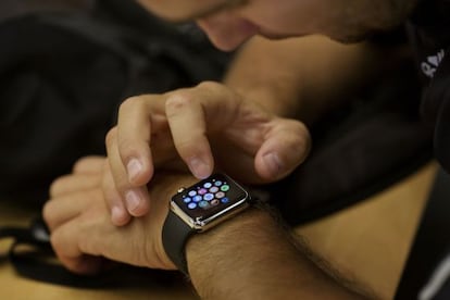 An employee sets up an Apple Watch for a customer at an Apple Inc. store, in New York, U.S., on Wednesday, June 17, 2015. Apple Inc. is rolling out a &quot;Reserve &amp; Pickup&quot; system which allows customers to choose a Watch online then buy and collect the order in store. Photographer: Victor J. Blue/Bloomberg