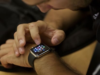 An employee sets up an Apple Watch for a customer at an Apple Inc. store, in New York, U.S., on Wednesday, June 17, 2015. Apple Inc. is rolling out a &quot;Reserve &amp; Pickup&quot; system which allows customers to choose a Watch online then buy and collect the order in store. Photographer: Victor J. Blue/Bloomberg