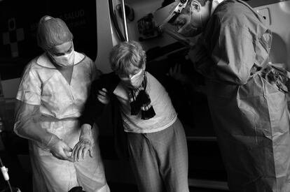Una enfermera y Santos ayudan a una anciana a bajarse de la ambulancia en el Hospital Universitario Central de Asturias.