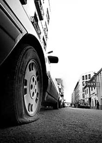 Coche con las ruedas rajadas, ayer, en la calle de Padre Porta.