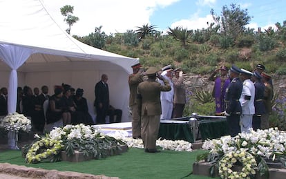 Varios militares saludan en posici&oacute;n de firme mientras el f&eacute;retro de Nelson Mandela desciende a la tumba. 