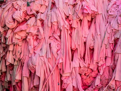 Primer plano de un montón de trozos de tela rosa para se tratado en una planta textil.