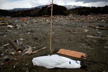 El cuerpo sin vida de una víctima del tsunami yace cubierto en la localidad de Rikuzentakat, Iwate.