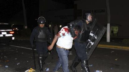 Un manifestante detenido por un policía en Acapulco.