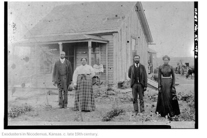 Colonos afroamericanos en Nicodemus, Kansas, después de la reconstrucción de sus casas.