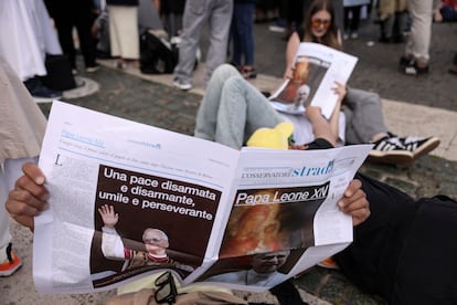 Varias personas leen el periódico en la plaza de San Pedro.