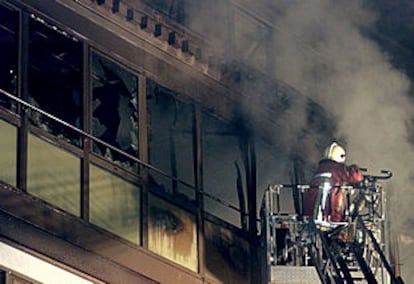 Un bombero belga trata de apagar las llamas de la representación española, ante la Unión Europea.