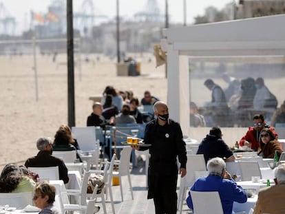 Un camarero atiende las mesas de una terraza en la playa de la Malvarrosa (Valencia), el 15 de marzo.