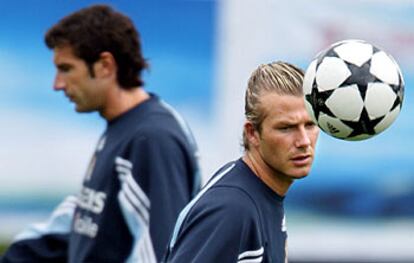 Figo y Beckham se cruzan a distancia, uno por cada banda en el entrenamiento de ayer.