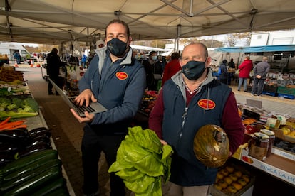 Carlos Gómez y su padre, Juan Gómez, en su puesto de  venta ambulante de fruta en Coslada.