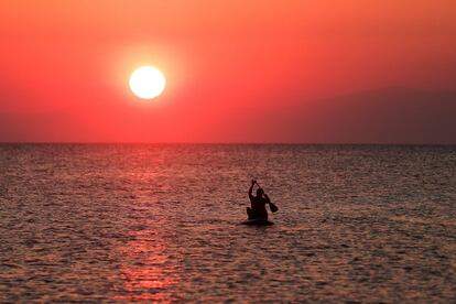 Un hombre rema al atardecer en la costa de Tesalónica, en Grecia.