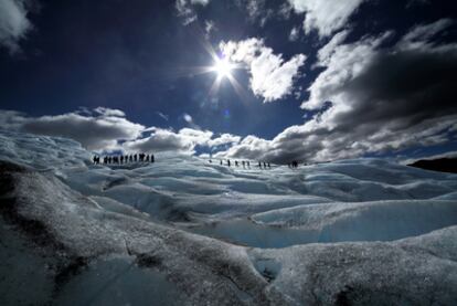 Una fila de excursionistas sobre el hielo de color azul eléctrico en el glaciar Perito Moreno (Argentina).