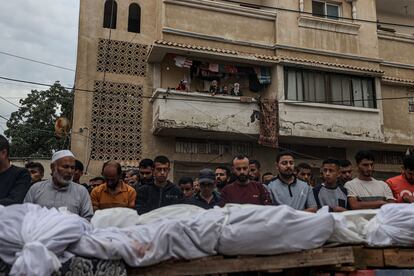 Varias personas asisten al funeral de la familia Kadih, cuyos miembros fueron asesinados durante los ataques israelíes, este lunes en Jan Yunis.