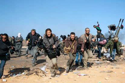 Imagen de archivo en la que se puede ver a un grupo de periodistas, entre ellos Tyler Hicks (derecha, con gafas), Linsey Addario (a la izquierda), saliendo a la carrera durante un ataque de las fuerzas libias a un puesto de control cerca de Ras Lanuf el pasado 11 de marzo.