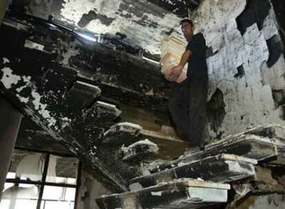Un hombre recoge libros quemados en la Biblioteca Nacional de Bagdad. Debajo, el bibliotecario Saad Eskander.
