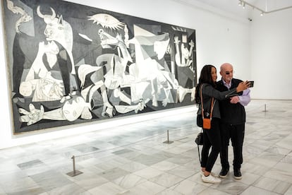 El escritor Salman Rushdie y su mujer, Rachel Eliza, se hacen un selfi junto al Guernica de Picasso en el Museo Reina Sofía, el 18 de mayo. 