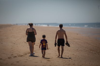 Una familia pasea por la playa de Punta Umbría (Huelva).