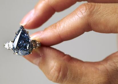 Un operario de Christie's muestra un diamante azul en una subasta