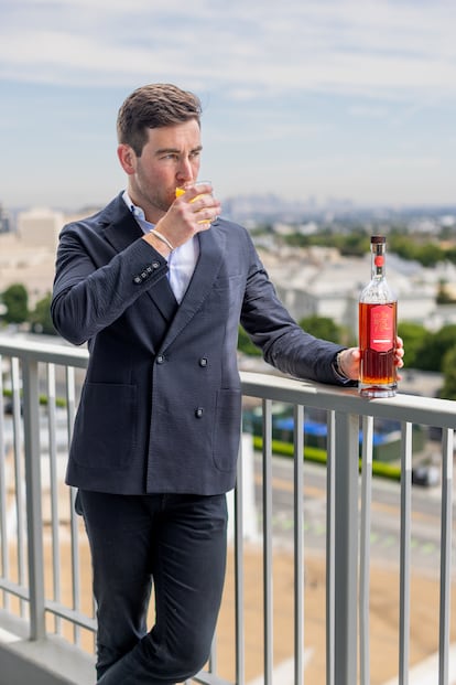 Andrew Borenzweig, fundador de la destilería Beverly Spirits, con el whisky creado para el 70º aniversario del hotel Beverly Hilton, en la terraza del hotel, en septiembre de 2025 en Beverly Hills (California).