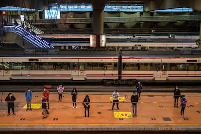 Passengers wait at a platform of Atocha train station in Madrid.