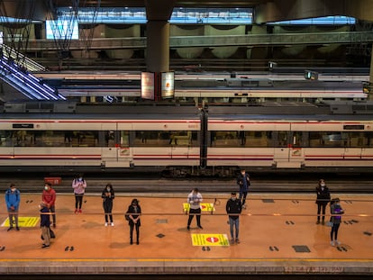 Passengers wait at a platform of Atocha train station in Madrid.