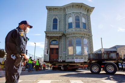 Un agente de policía de San Francisco supervisa el traslado de la conocida como Englander House en una intersección.