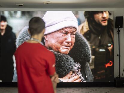 Un hombre observa las fotografías exhibidas en la Casa de los Crímenes de Guerra de Rusia, en Davos, este domingo.