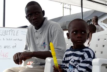 Emmanuel junto a su padre el día en el que ambos fueron dados de alta. Su madre y su hermana pequeña no sobrevivieron a la enfermedad.