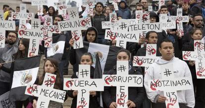 Varios manifestantes portan pancartas para protestar por la desaparición de los estudiantes de Iguala.
