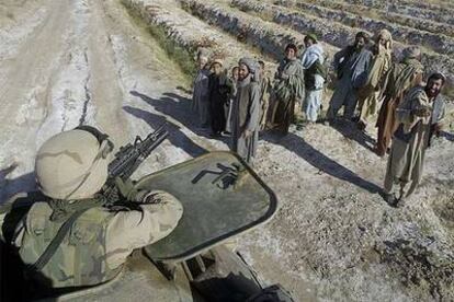 Un tanque de Estados Unidos pasa por delante de un grupo de campesinos afganos en diciembre de 2001.