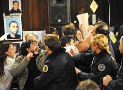 Familiares de las víctimas descontentos con el veredicto se enfrentan a la policía en la sala del juicio.