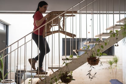 Lupe Murcia sube al primer piso de su casa una silla, para limpiarla del barro de la riada en Aldaia. 
