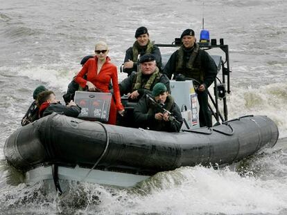 La modelo Tuuli Shipser, escoltada por militares, lleva en un maletín los primeros ejemplares del libro durante la presentación ayer en Londres.