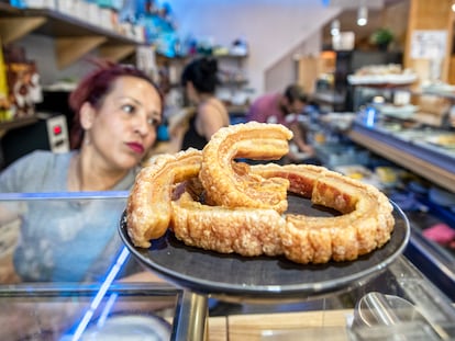 Una camarera sirve un plato de torreznos en el bar Antonio de San Esteban de Gormaz (Soria).