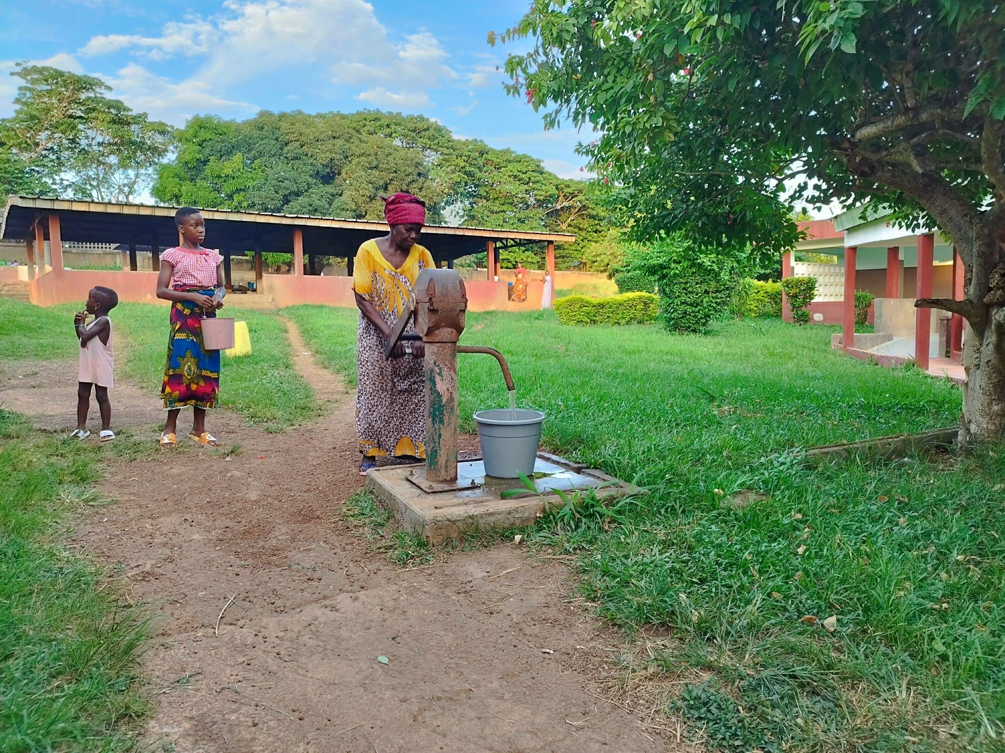 Una mujer, acompañante de un paciente, extrae agua para el consumo de un pozo en el hospital Saint Michel de Zoukougbeu.